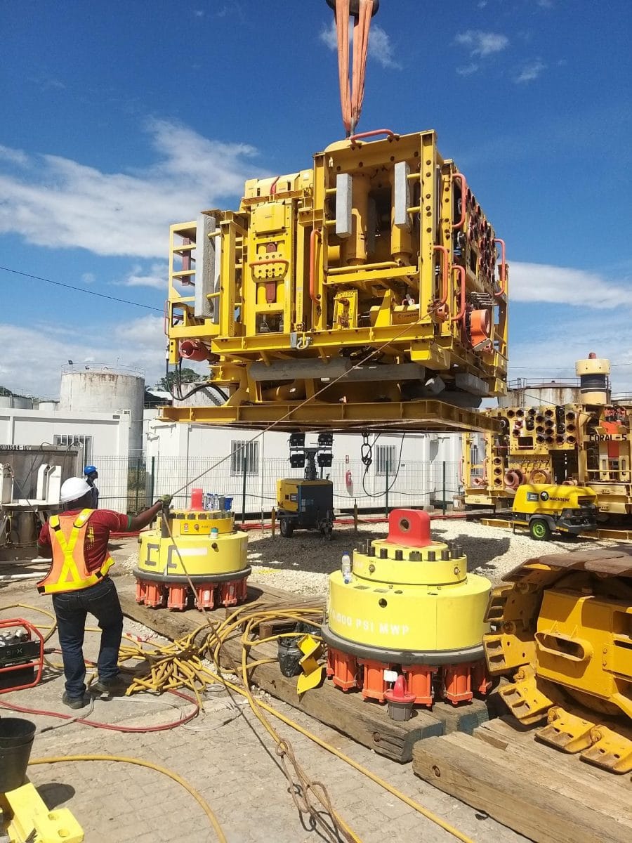 A worker uses a handheld device paired with Straightpoint load cell & Crosby shackles to obtain the weight of the object being lifted