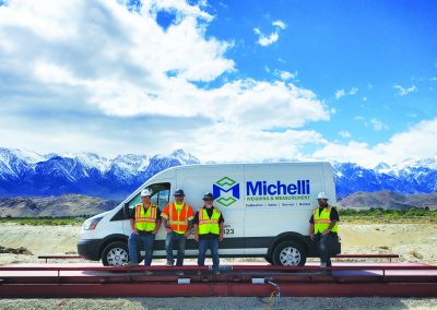 Michelli Service Technicians on BTEK scale in front of mountains