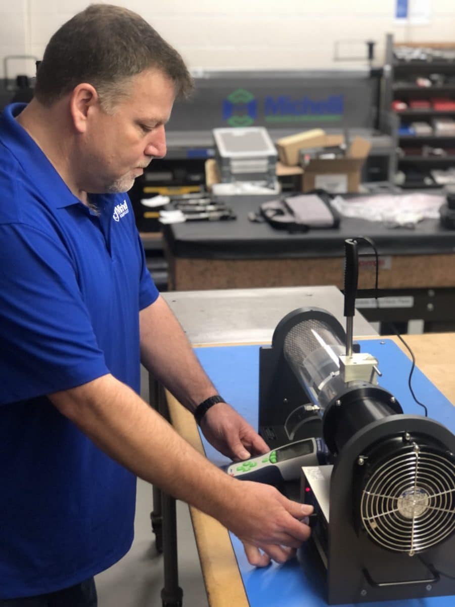 Michelli technician performs environmental calibration on an anemometer using a wind tunnel