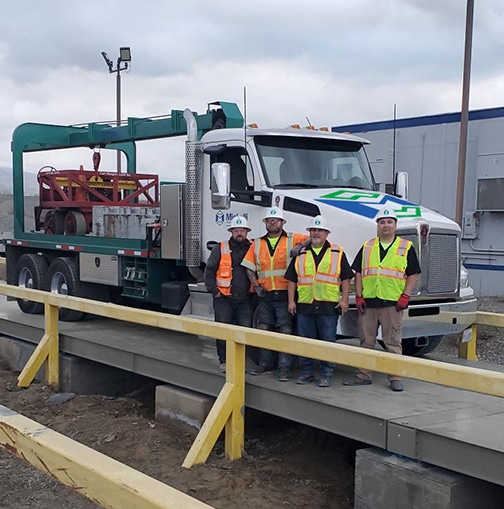 Michelli team poses with a heavy duty test truck on a truck scale