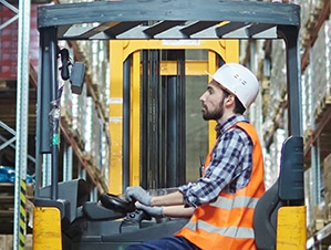 Worker in a forklift using a forklift scale