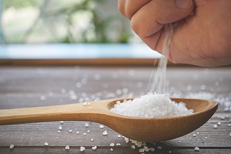 Using a spoon to measure salt