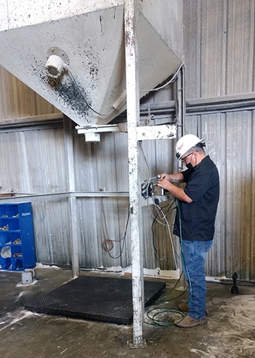 Michelli service technician works on a medium capacity scale under hopper