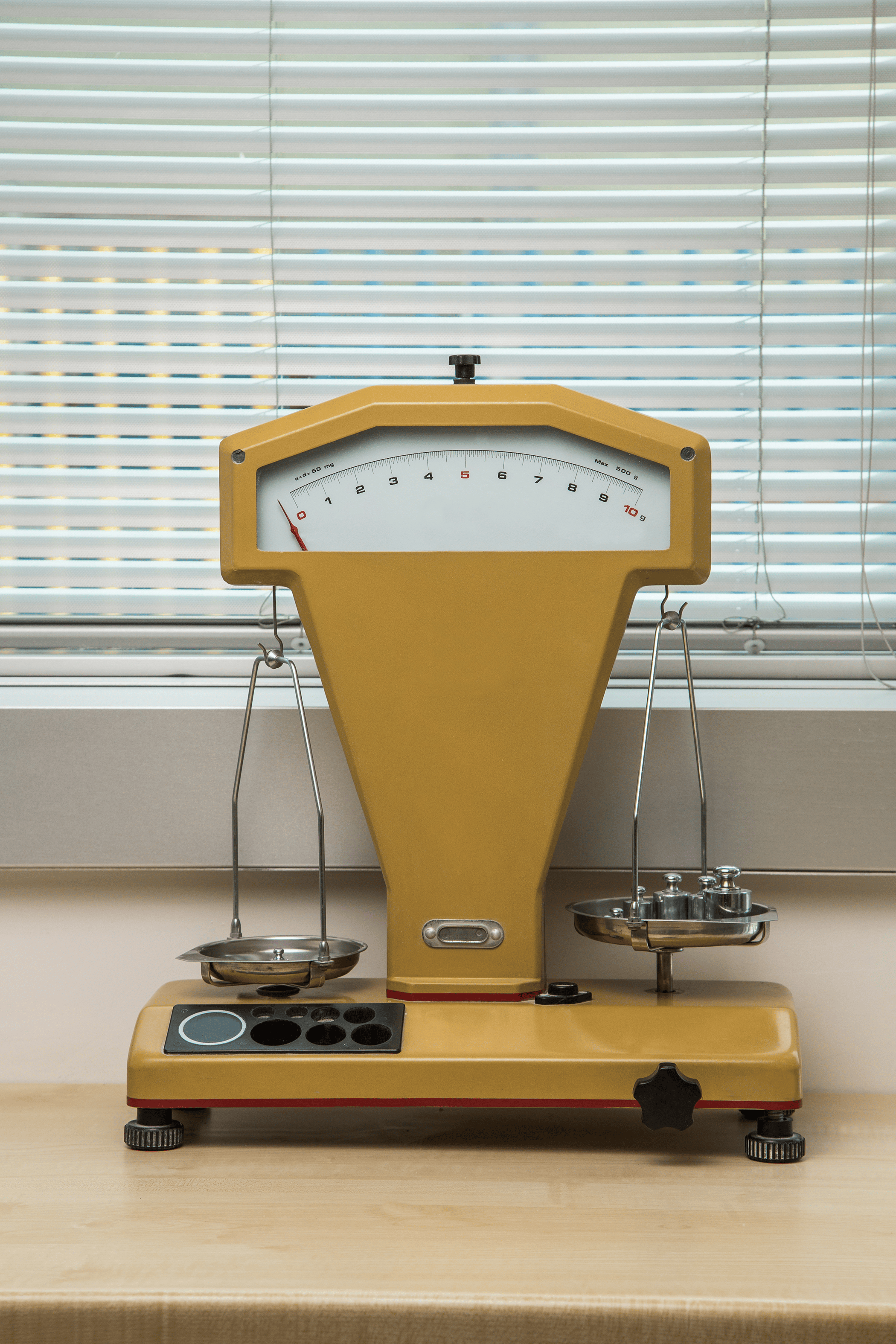 Yellow lab balance with calibration weights on one plate