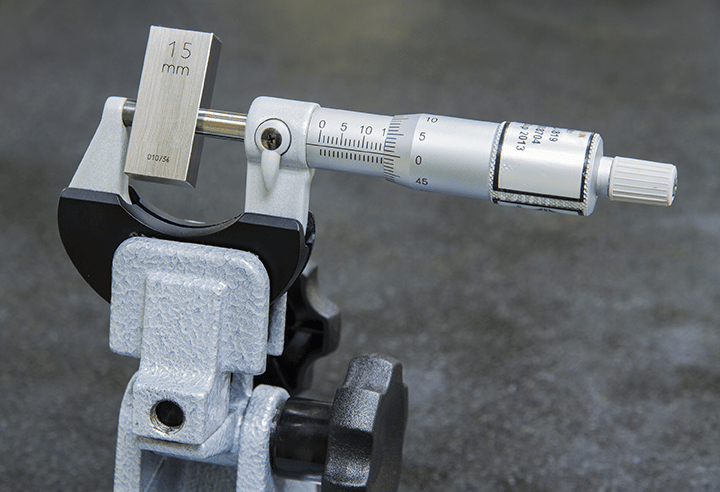 Mechanical micrometer calibration with gage block in progress