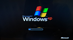 Windows XP logo on black computer screen during startup