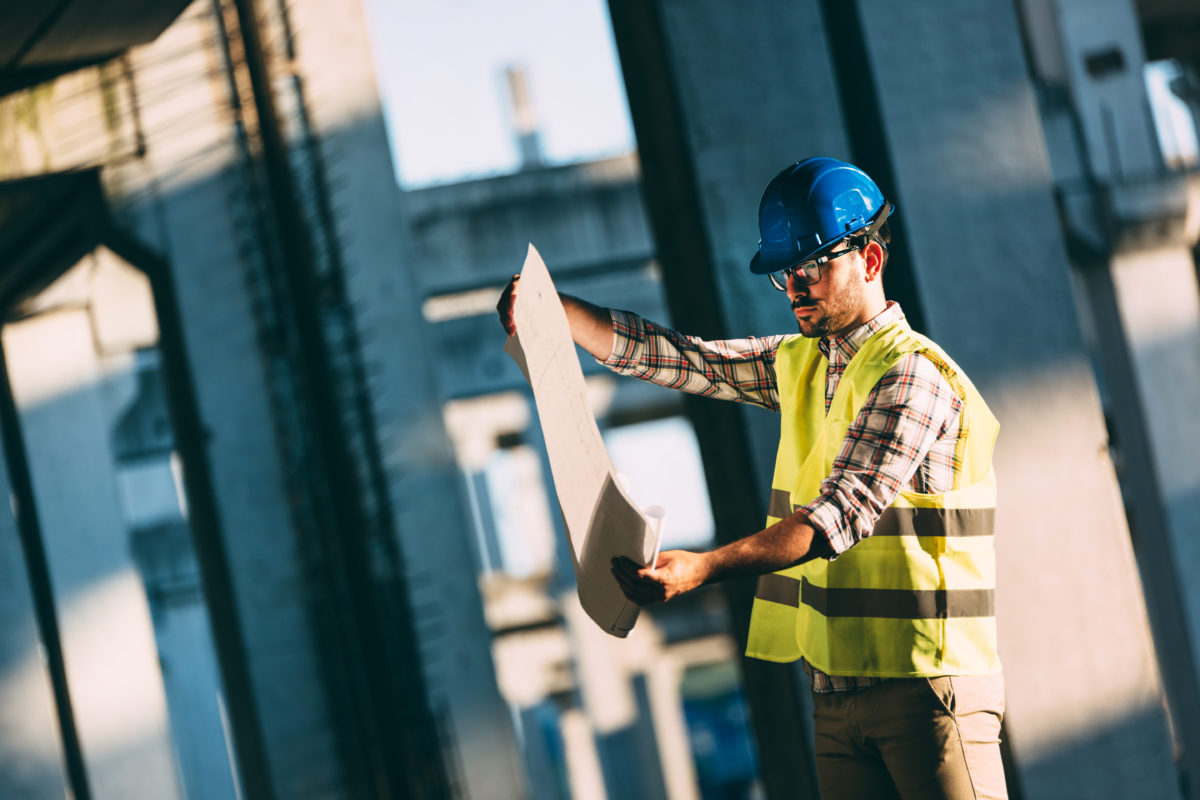 Picture of construction site engineer looking at plan