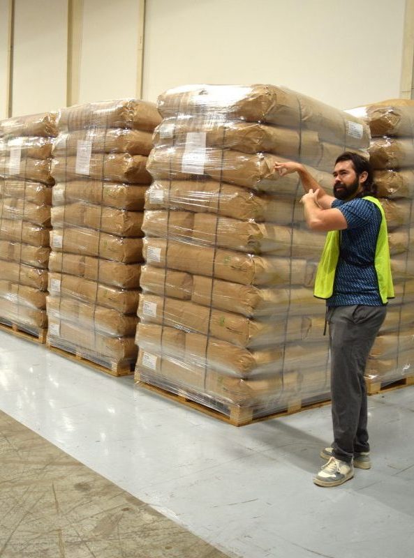 Workers at Green Shutter Tea stand near blended tea packaged with their new quality control weighing system