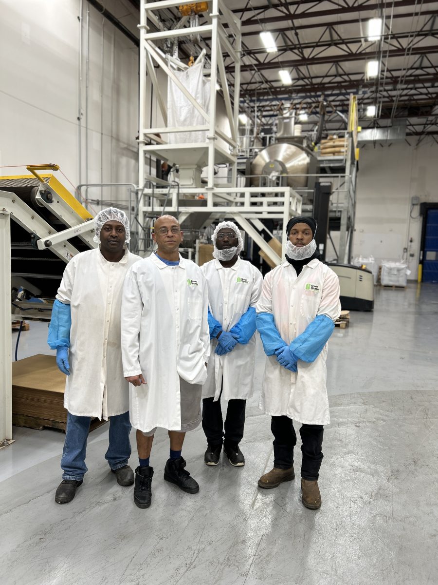 Green Shutter Tea employees in the packaging facility learning to use their quality control weighing system